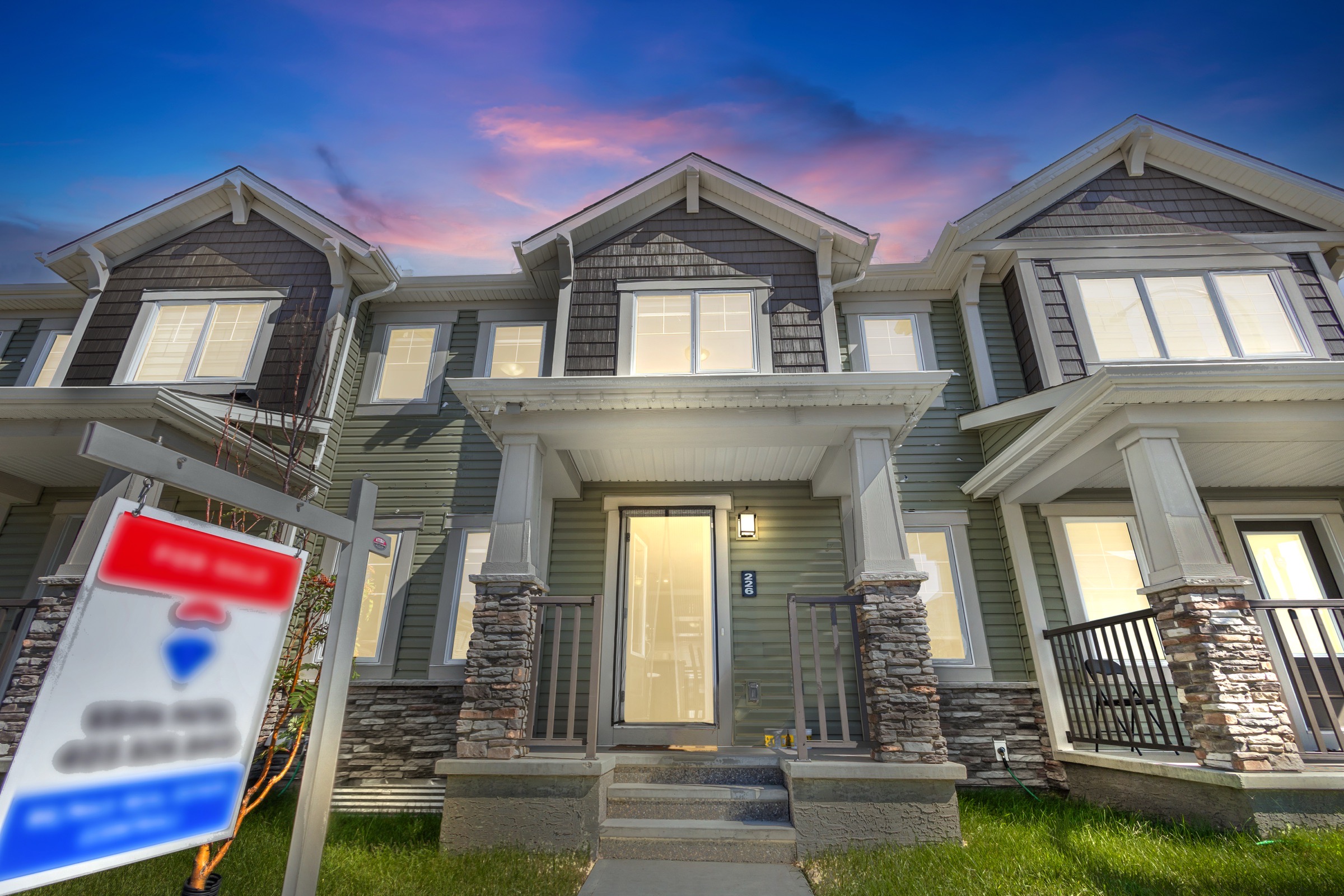Townhome exterior at twilight with a replaced sky