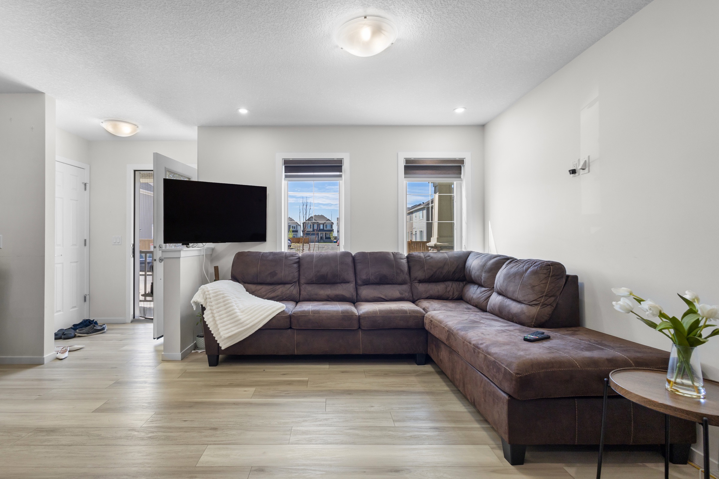 Bright living room with a sectional sofa and wide-plank flooring