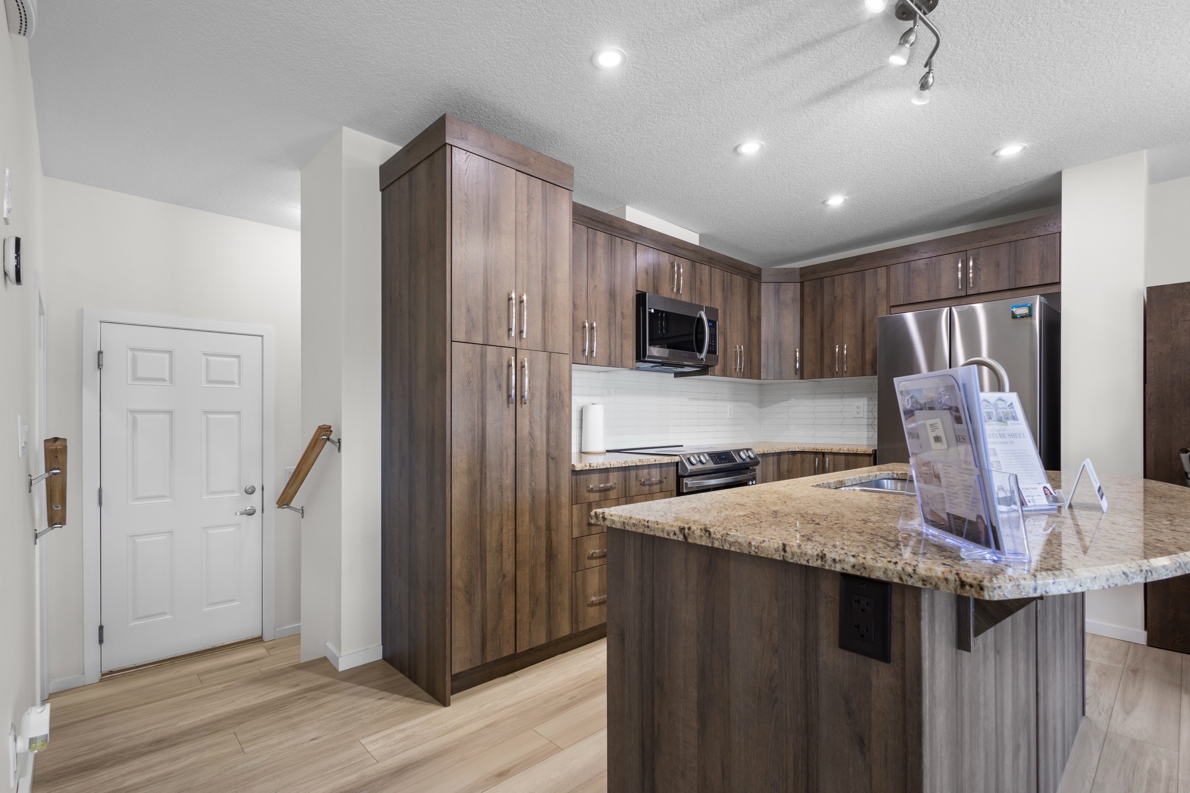 Kitchen with granite island, dark wood cabinetry and stainless appliances
