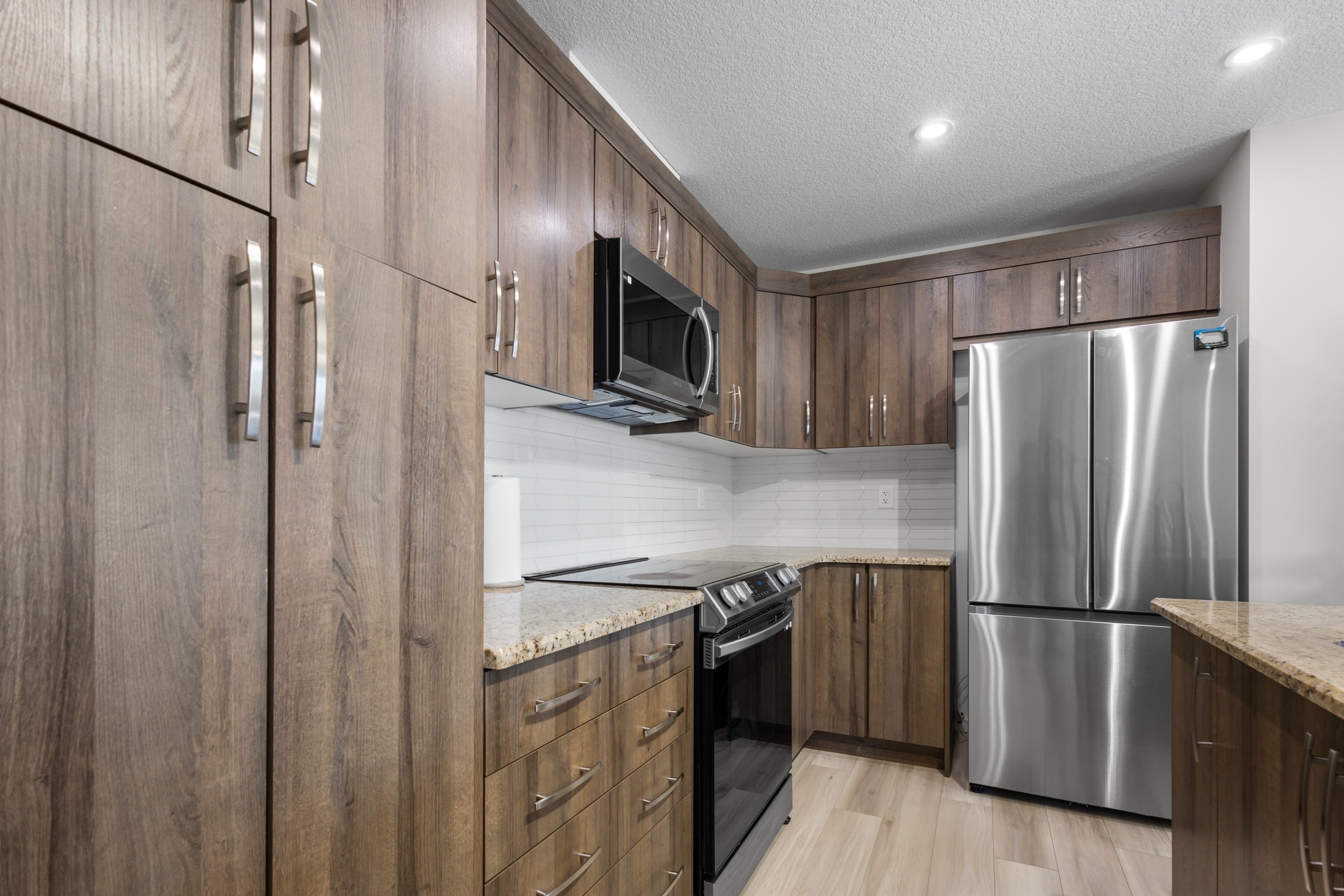 Kitchen from the galley side showing the range, fridge and cabinetry