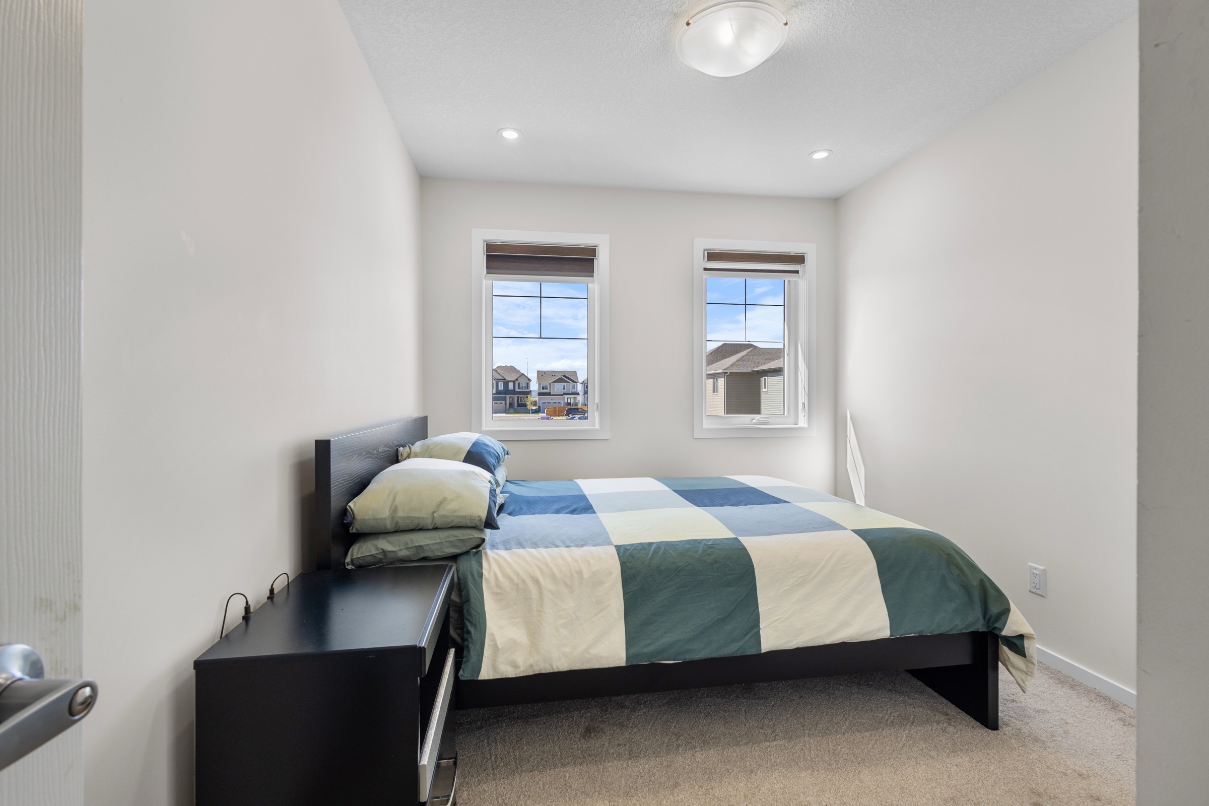 Second bedroom with twin windows and neutral carpet