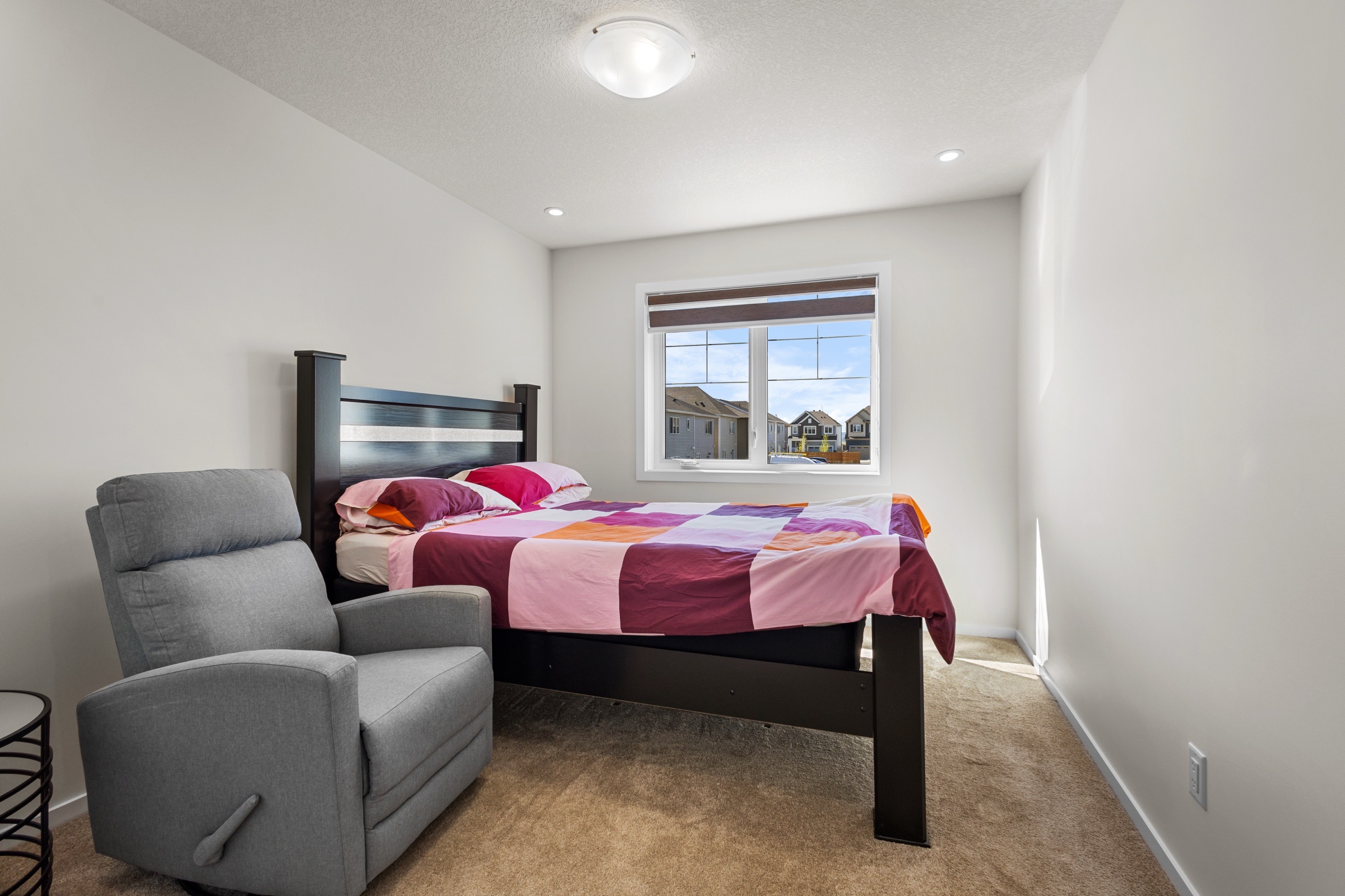 Third bedroom with a reading chair beside the window